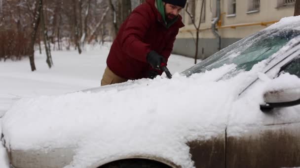 在居住小区里 男人用刷子擦车雪 人的镜头 — 图库视频影像