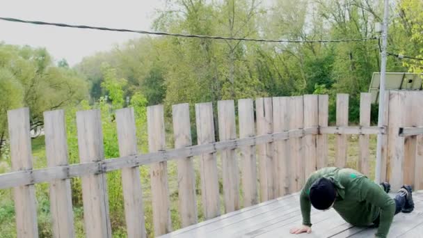 Joven fuerte haciendo flexiones. Hombre Ahlete Deportista Entrenamiento Entrenamiento al aire libre Verano Haciendo Ejercicios Empuje hacia arriba. Entrenamiento atlético, Educación física . — Vídeo de stock