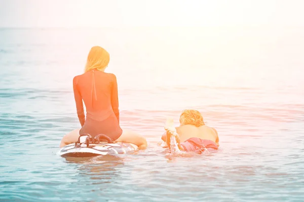 Surfistas en la playa- Pareja sonriente de surfistas nadando en el mar y divirtiéndose en verano. Deporte extremo y concepto de vacaciones —  Fotos de Stock