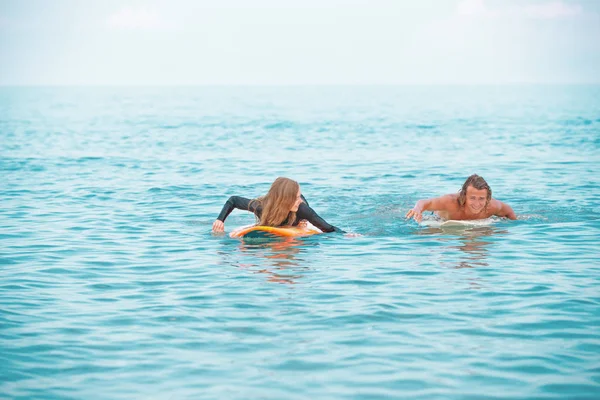 Surfeurs à la plage.Un couple souriant de surfeurs marchant sur la plage et s'amusant en été. Concept de sport extrême et vacances — Photo