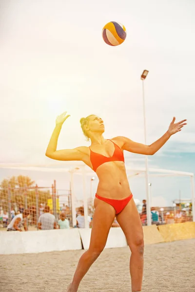 La joueuse de volleyball de plage est une athlète féminine qui se prépare à servir la balle sur la plage. . — Photo