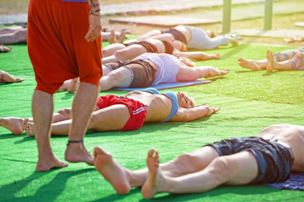 Gran grupo de adultos asistiendo a una clase de yoga al aire libre en el parque — Foto de Stock