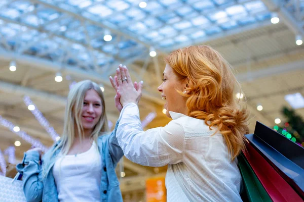 Két gyönyörű fiatal nő, egy bevásárló központban ellenőrzésének táska — Stock Fotó