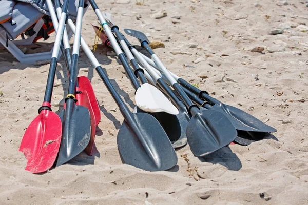 Remos de barco jazem na areia na praia junto ao mar — Fotografia de Stock