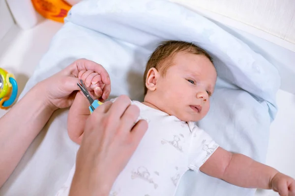 Primer plano de la madre cortando las uñas de los bebés con tijeras. Amamantar a un niño . —  Fotos de Stock