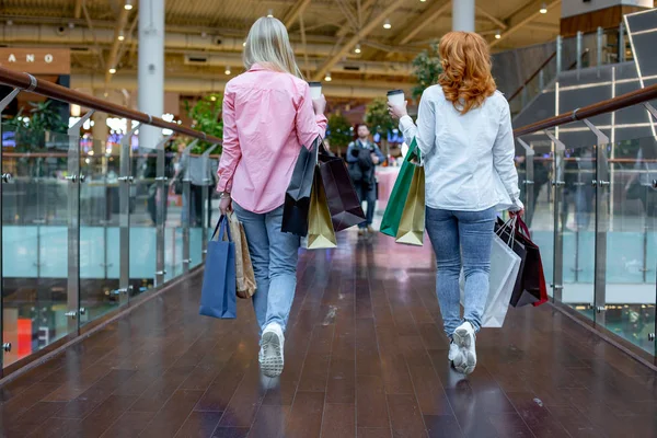 Boldog fiatal nő élvezi a bevásárló táskák, lányok nem szórakozik a vásárlást. nézet hátulról. Fogyasztás és az életmód fogalma — Stock Fotó