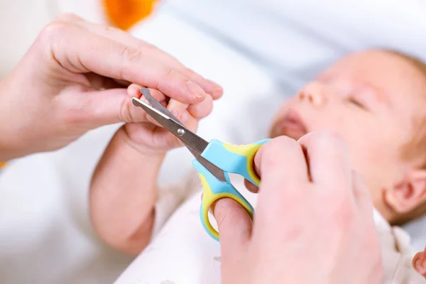 关闭母亲用剪刀剪婴儿指甲。照顾孩子. — 图库照片