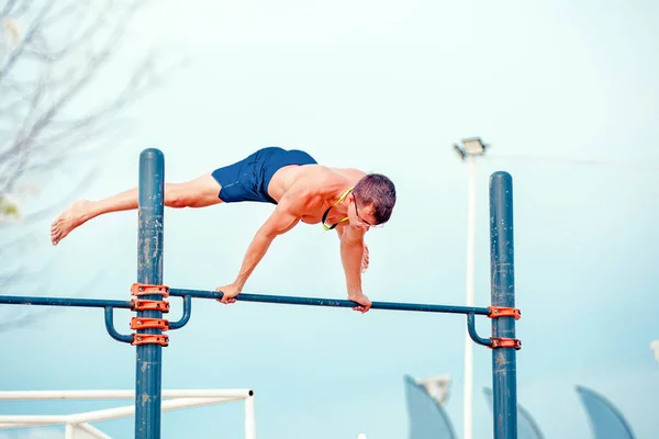 Joven haciendo ejercicio en el campo de deportes — Foto de Stock