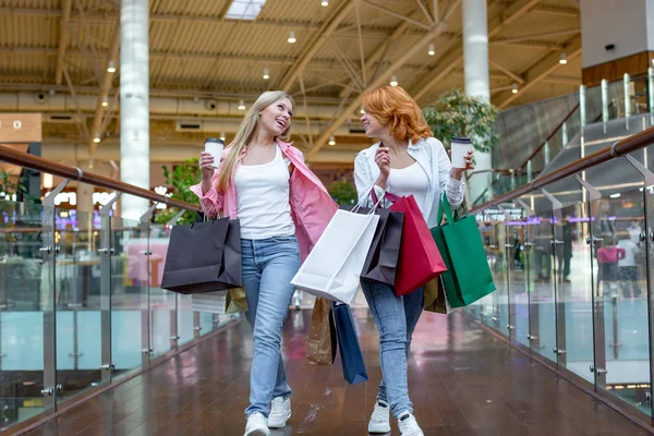快乐的年轻妇女与购物袋享受购物, 女孩们有乐趣与他们的购买。消费主义和生活方式概念 — 图库照片
