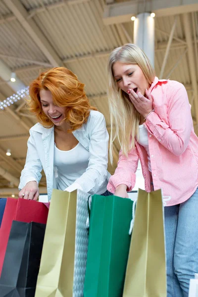 Due belle giovani donne in un centro commerciale a controllare le borse — Foto Stock