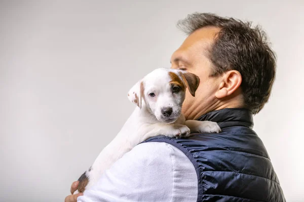 Horizontal portrait of handsome cheerful man holds jack russell terrirer, has glad expression — Stock Photo, Image