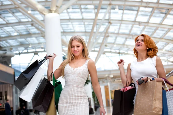 Mujeres jóvenes felices con bolsas de compras disfrutando en las compras, las niñas se están divirtiendo con sus compras. Concepto de consumo y estilo de vida — Foto de Stock