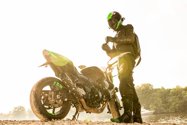 Hombre motociclista y motocicleta con fondo de río, paseo en moto jinete en la calle a orillas del río, disfrutando de la libertad y el estilo de vida activo . —  Fotos de Stock