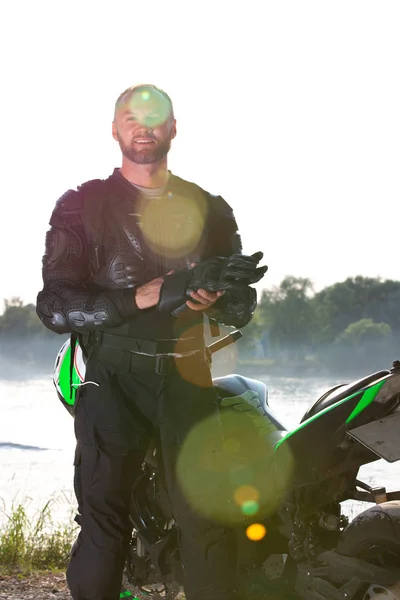 Hombre motociclista y motocicleta con fondo de río, paseo en moto jinete en la calle a orillas del río, disfrutando de la libertad y el estilo de vida activo . —  Fotos de Stock