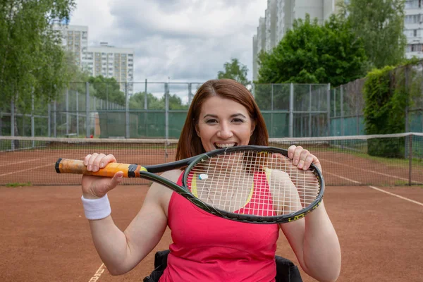 Handikappad ung kvinna på rullstolen spela tennis på tennisbanan. — Stockfoto