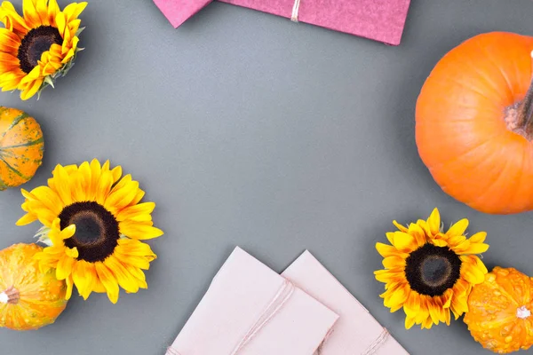 Top view of handcraft gift box, yellow flowers and pumpkins on gray background. Blank greeting card for creative work design. flat lay — Stock Photo, Image