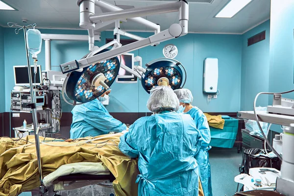 Několik chirurgové kolem pacienta na operaci stůl během jejich práce — Stock fotografie