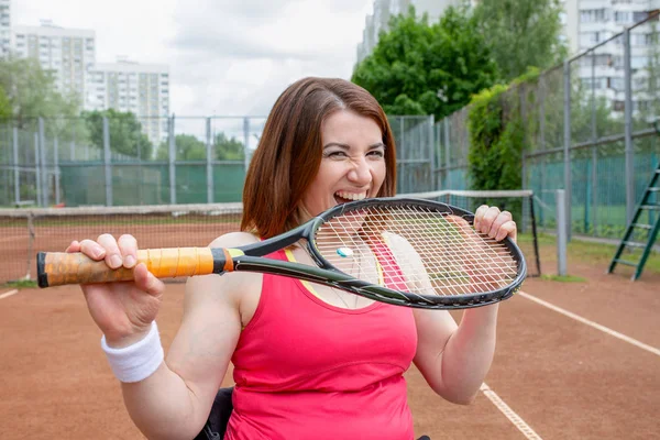 Una deportista exitosa muerde raqueta en la cancha de tenis. Estilo de vida saludable . — Foto de Stock