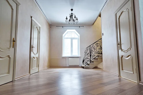 Entrance hallway with staircase. View of steps with wrought iron railings