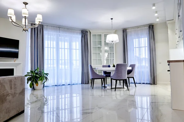 Interior minimalista da sala de estar em tom claro com piso de mármore, grandes janelas e uma mesa para quatro pessoas — Fotografia de Stock