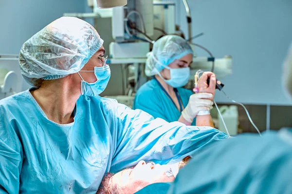 Concepto de cirugía, medicina y personas - grupo de cirujanos en operación en quirófano en el hospital — Foto de Stock