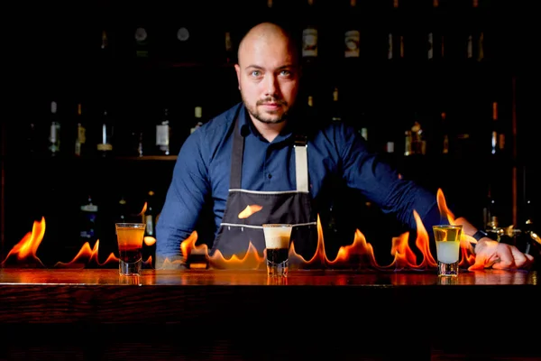 Ohnivá show v baru. Barman dělá horké alkoholických koktejlů a zapálí bar. Barman připravuje ohnivý koktejl. Oheň na baru. — Stock fotografie