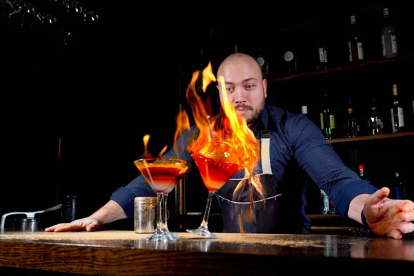 Ohnivá show v baru. Barman dělá horké alkoholických koktejlů a zapálí bar. Barman připravuje ohnivý koktejl. Oheň na baru. — Stock fotografie