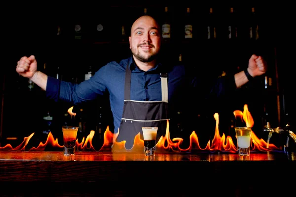 Ohnivá show v baru. Barman dělá horké alkoholických koktejlů a zapálí bar. Barman připravuje ohnivý koktejl. Oheň na baru. — Stock fotografie