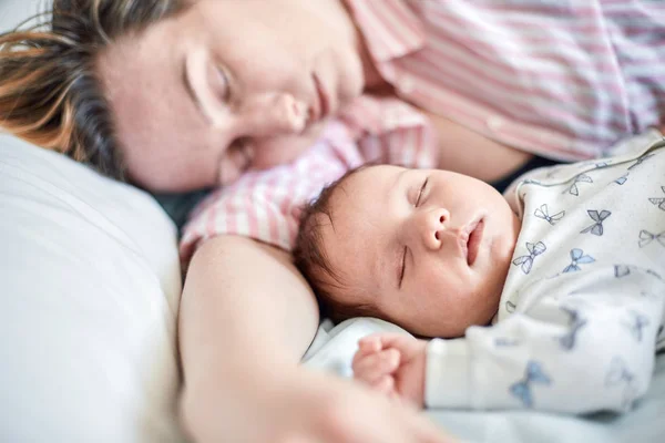 Retrato de bebê recém-nascido e mãe dormindo na cama, descansando juntos — Fotografia de Stock