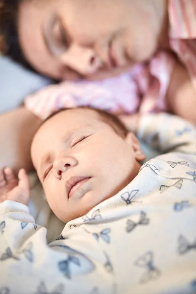 Porträtt av nyfött barn och mor sova på sängen, vila tillsammans — Stockfoto