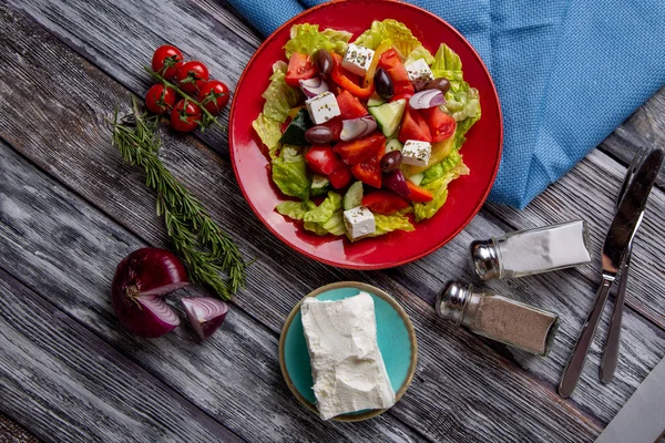 Салат «грецький» з свіжі огірки, помідори, солодкий перець, салату, червоний лук, сиром Фета та оливками з оливковою олією з дерев'яними тлі. Здорове харчування — стокове фото