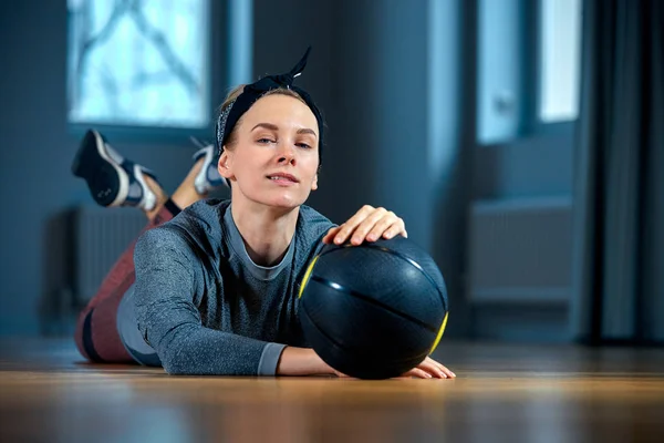 Güzel kadın spor giyim ile basketbol, spor salonu ve sağlıklı kız yaşam tarzı ve spor kavram pencerenin önünde yerde yatarken süre poz içinde uygun — Stok fotoğraf