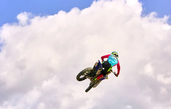 Motocross Rider Saltar em um céu azul com nuvens — Fotografia de Stock