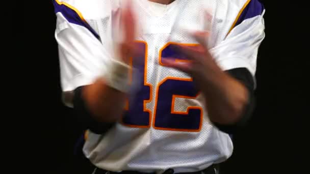 American football. American football player claps hands close-up. Preparing for the game. Motivation for the game, close-up, black background. — Stock Video