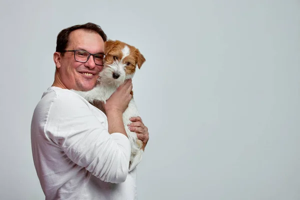 Собака лежить на плечі свого власника. Джек Рассел тер'єр в його власників руки на білому тлі. Концепція людей і тварин. T — стокове фото