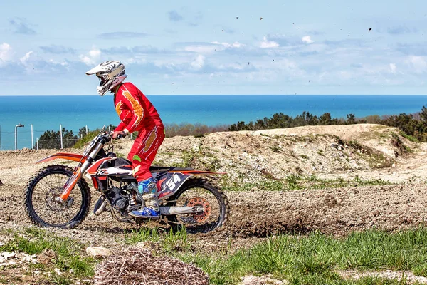 Moto extreme motorcycle rides through the mud against the backdrop of the sea coast