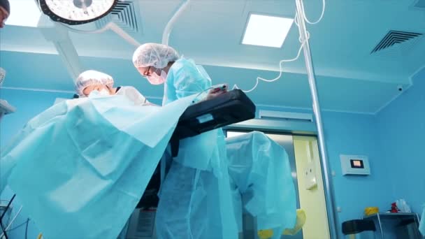 Team van professionele chirurgen het uitvoeren van invasieve chirurgie op een patiënt in het ziekenhuis operatiekamer. Gebruik van chirurgen en andere instrumenten — Stockvideo