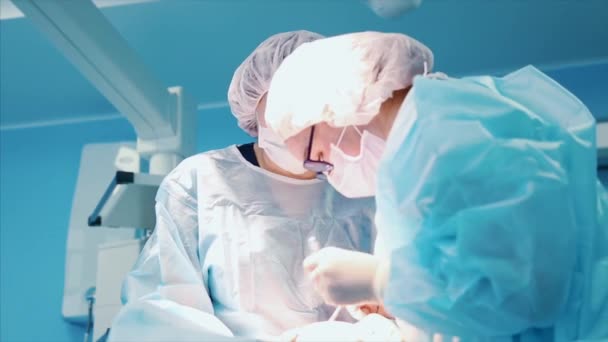 Chirurg op het werk. een team van professionele chirurgen voert chirurgie op de patiënt. Echte operatiekamer. Medische concept. Close-up — Stockvideo