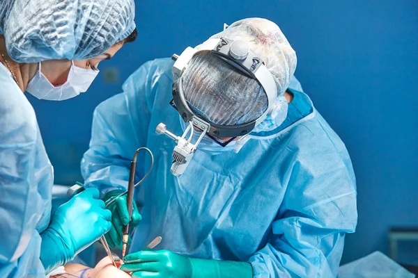 A equipa de cirurgiões faz uma operação invasiva. Retrato de cirurgiões de perto. Trabalhar com um instrumento coagulante, coagulação vascular — Fotografia de Stock