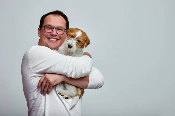 Собака лежить на плечі свого власника. Джек Рассел тер'єр в його власників руки на білому тлі. Концепція людей і тварин. T — стокове фото