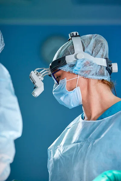 Close up portrait of female surgeon doctor wearing protective mask and hat during the operation. Healthcare, medical education, surgery concept. — Stock Photo, Image