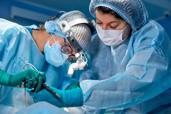 El equipo de cirujanos hace una operación invasiva. Retrato de cirujanos de cerca. Trabajar con un instrumento coagulante, coagulación vascular — Foto de Stock