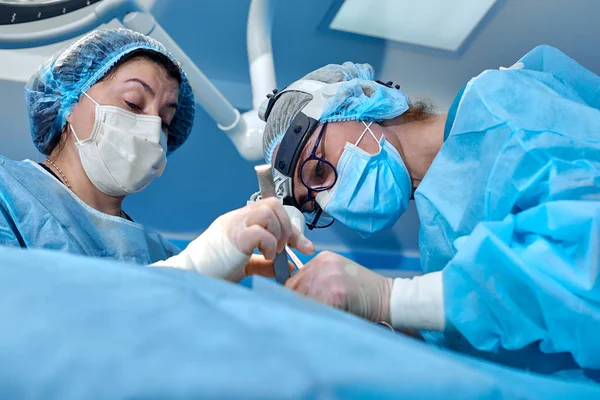 Concepto de cirugía, medicina y personas - grupo de cirujanos en operación en quirófano en el hospital —  Fotos de Stock