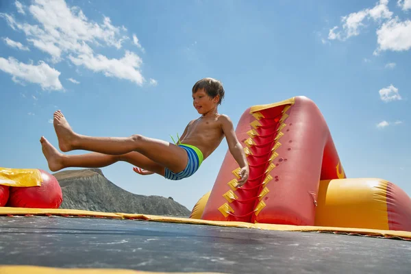 화창한 날에는 바다에 물 trampoline에 재생 하는 소년 — 스톡 사진