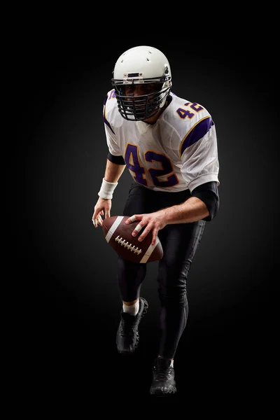 American football sportsman player on black background. Sport concept.