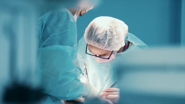 Chirurg op het werk. een team van professionele chirurgen voert chirurgie op de patiënt. Echte operatiekamer. Medische concept. Close-up. — Stockvideo