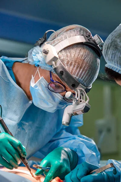 Retrato de cerca de la doctora cirujana usando máscara protectora y sombrero durante la operación. Salud, educación médica, concepto de cirugía . — Foto de Stock