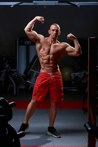 Hombre atlético posando. Foto de hombre con físico perfecto sobre fondo negro. Fuerza y motivación —  Fotos de Stock