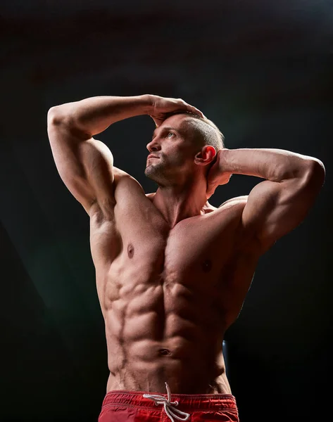Homem atlético posando. Foto do homem com físico perfeito sobre fundo preto. Força e motivação — Fotografia de Stock