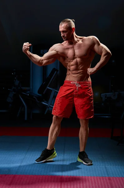 Homem atlético posando. Foto do homem com físico perfeito sobre fundo preto. Força e motivação — Fotografia de Stock